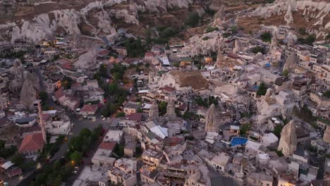 Vista-Aérea-Al-Anochecer-Con-La-última-Luz-Proyectada-Sobre-La-Ciudad-Excavada-En-Piedra-En-El-Valle,-Capadocia,-Turquía