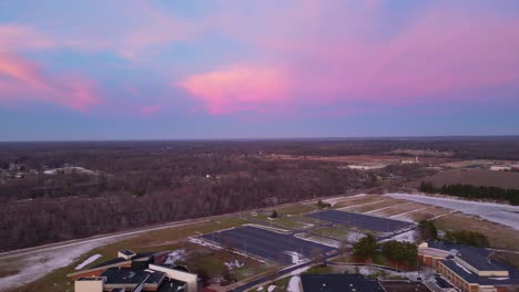 Drone-shot-capturing-a-vivid-sunset-over-a-snow-dusted-landscape