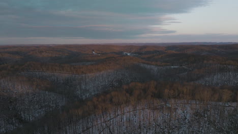 Deciduous-tree-forest-with-dusting-of-snow-covering-rolling-hills-in-middle-Tennessee-at-dusk