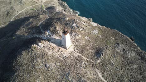 A-remote-lighthouse-on-a-rocky-island-coastline-in-los-roques,-venezuela,-aerial-view