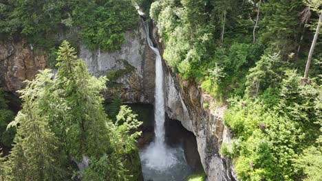 Aerial-drone-image-ascending-to-reveal-the-beautiful-Berglistüber-Waterfall,-located-in-Fätschbach,-Glarus-Süd,-Switzerland