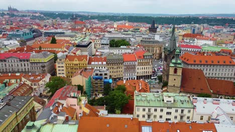 Aerial-drone-view-of-Prague,-colorful-buildings,-red-rooftops,-church-tower-and-tram-on-street-in-Czech-Republic