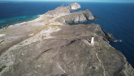 A-lighthouse-on-a-rugged-coastal-landscape-near-gran-roque,-venezuela,-aerial-view