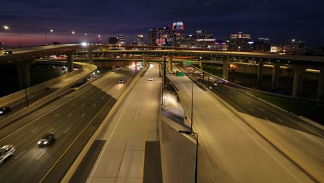 Interstate-highways-lit-up-at-night-in-downtown-Orlando,-with-light-traffic-flowing-under-overpasses