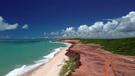 AERIAL:-Off-road-vehicle-on-the-rocky-coastline-of-Chapadao,-Brazil,-sunny-day