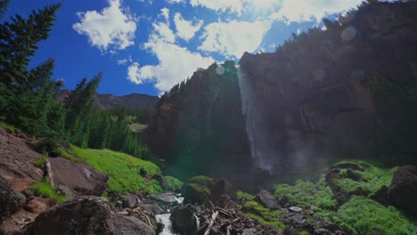 Summer-Telluride-Box-Canyon-Bridal-Veil-Falls-Waterfall-Colorado-landscape-pan-down-slowly-cliffside-Powerhouse-Hydroelectric-power-plant-Black-Bear-Pass-Board-sunny-blue-sky-clouds-mist-spray-scenery