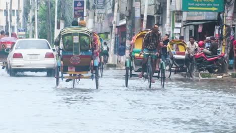 Floodwaters-Have-Inundated-the-Streets,-Making-it-Difficult-for-People-to-Drive-Vehicles-and-Rickshaws-in-Sylhet,-Bangladesh,-South-Asia---Handheld-Shot