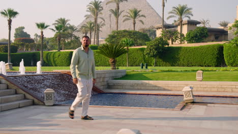 Man-Walking-On-The-Swimming-Pool-Of-A-Luxury-Complex-Hotel-Near-Giza-Pyramids-In-Egypt