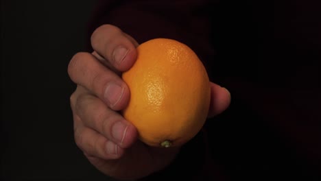 Hand-holding-a-fresh,-ripe-lemon,-highlighting-its-smooth-texture-and-vibrant-color-for-healthy-eating