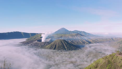 Aerial-tracking-shot-of-a-tourist-overlooking-Mount-Bromo-crater-beautiful-landscape