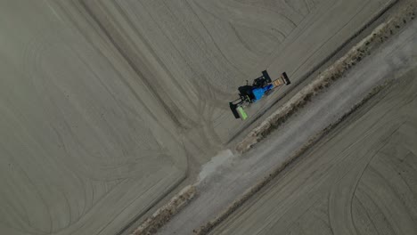 Un-Tractor-Trabajando-En-Gelsa,-Zaragoza,-En-Tierras-De-Cultivo-Secas-Y-Llanas-Durante-El-Día,-Vista-Aérea