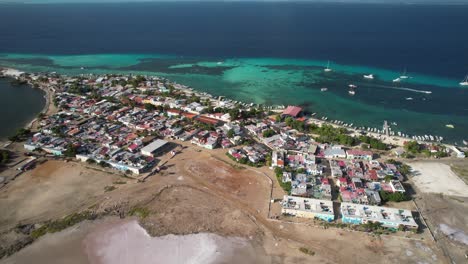 Colorful-coastal-town-by-the-sea-with-boats-and-turquoise-waters-in-los-roques,-aerial-view