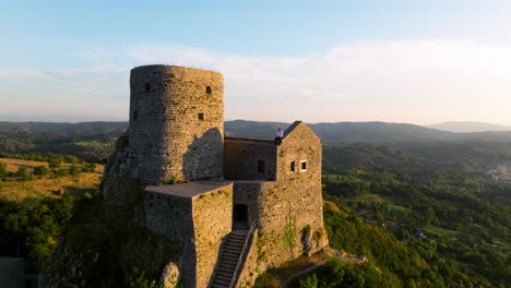 Male-Traveler-Sitting-On-Srebrenik-Castle-With-Scenic-Sunset-Overview-In-Tuzla,-Bosnia-and-Herzegovina