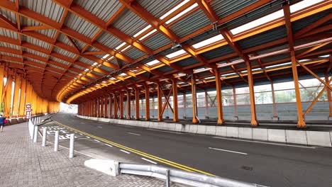 Orange-metal-tunnel-in-Hong-Kong-with-some-traffic-and-pedestrians