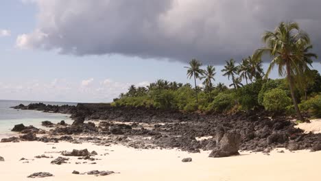 A-serene-tropical-beach-with-white-sand-and-rocky-coastline-on-a-sunny-day