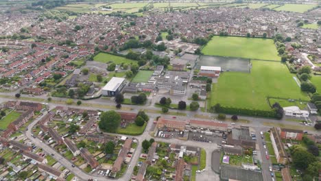 Aerial-drone-fly-in-of-the-Bridgwater-College-Academy-highlighting-campus-buildings,-sports-fields,-and-surrounding-area,-Bridgwater,-United-Kingdom