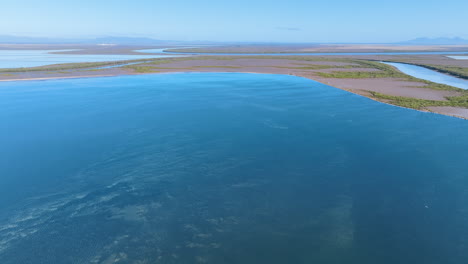 Aerial-cruises-above-the-science-fiction-like-landscapes-of-the-Port-Alma-region-near-Rockhampton,-featuring-shallow-azure-ponds,-vibrant-green-mangroves,-and-an-endless-horizon