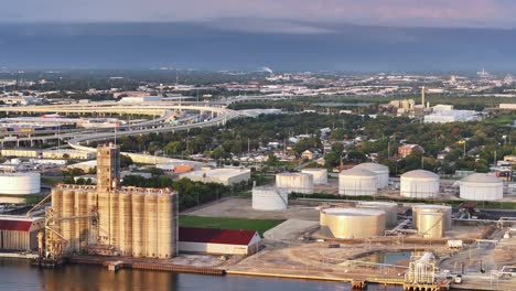 Industrial-tanks-and-silos-line-the-waterfront-in-Tampa,-Florida,-near-major-highway-overpasses