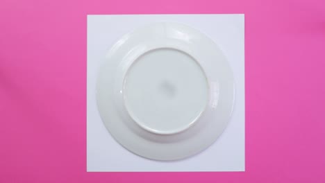 Using-porcelain-plate-to-draw-circumference-on-paper,-pink-background