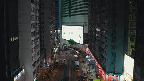 Drone-shot-traveling-upward-in-the-middle-of-the-city-of-Hong-Kong-in-Causway-Bay-crossroad-during-the-night