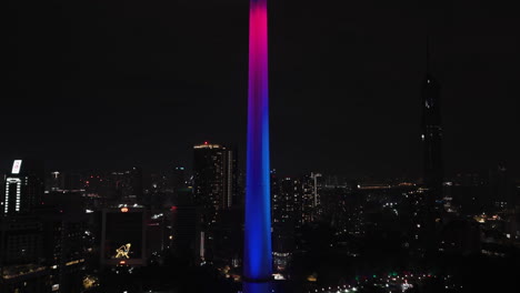 Luftaufnahme-In-Richtung-Des-Beleuchteten-Kuala-Lumpur-Towers,-Nacht-In-Malaysia