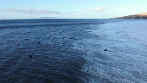 flying-out-over-lots-of-surfers-sitting-and-waiting-for-waves-during-record-swell-on-maui-hawaii