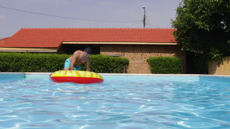 Male-Model-Riding-A-Inflatable-Floatie-In-A-Outdoor-Swimming-Pool-During-Summer