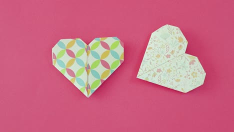 Corazones-De-San-Valentín-Hechos-Con-Papel-Origami-Decorativo-Sobre-Papel-Rosa