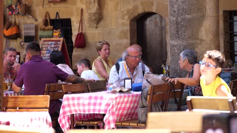 Tourists-Seen-Dining-Outside-In-Nicosia-With-Child-Running-Past