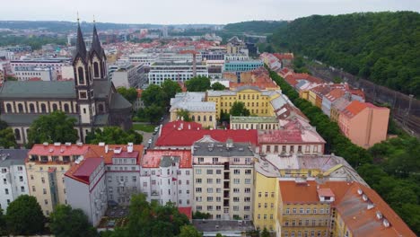 Aerial-view-of-Prague,-colorful-buildings,-church-rooftops-and-greenery,-Czech-Republic