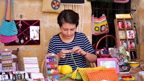 Local-Seller-Threading-Yellow-Yarn-Through-Needle-Outside-In-Nicosia