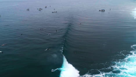 Drone-overview-of-crashing-wall-of-wave-water-at-Cloudbreak-Fiji-above-surfers