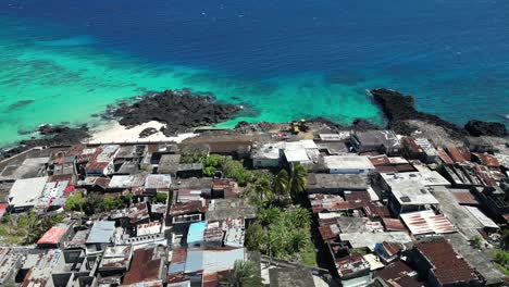 Aerial-View-Along-Coastal-Slum-Neighborhood-In-Comoros,-Poor-Populated-Urban-Residential-Area-With-Dense-Houses