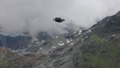 Concentrated-pilot-takes-off-drone-from-hand,-flying-in-majestic-mountain-landscape