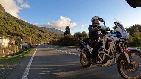 Biker-on-adventure-motorcycle-riding-on-rural-asphalt-road