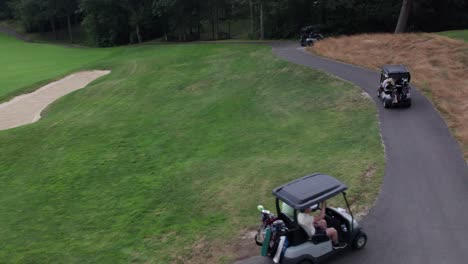 A-drone-follows-behind-a-group-of-golfers-in-carts-as-they-move-to-the-next-hole