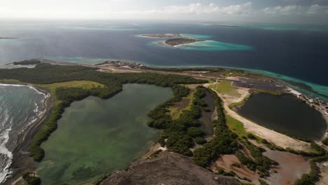 Los-roques-with-turquoise-waters,-lush-islands,-and-runway-at-gran-roque-,-aerial-view