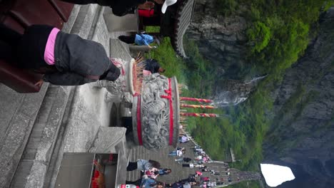 People-bow-and-pray-before-climbing-the-999-Stairs-to-Tianmen-Cave,-Zhangjiajie