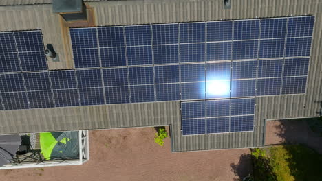 AERIAL:-Sunlight-mirroring-from-the-photovoltaic-surface-on-a-modern-house-roof