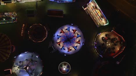 Experience-the-vibrant-energy-of-an-amusement-park-at-night-with-this-breathtaking-aerial-view-of-flashing-fairground-rides