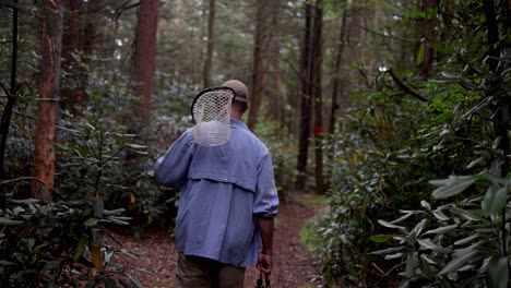 Slow-Motion-tracking-shot-of-a-Fly-Fisherman-in-the-Pocono-Mountains-in-Pennsylvania-walking-towards-the-stream