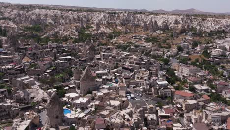 Panoramic-aerial-establishing-overview-of-homes-growing-out-of-rock-towers-in-Cappadocia-Turkey-at-midday