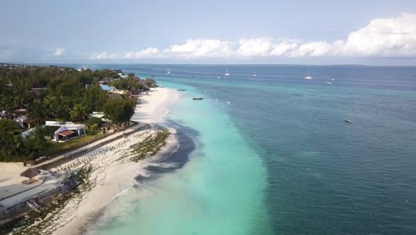 Aerial-descending-over-white-sand-beach-on-Zanzibar-coast,-Tanzania