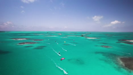 Kite-surfers-glide-over-turquoise-waters-surrounded-by-small-islands-under-a-clear-sky