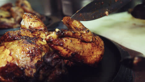 eautiful-slow-motion-shot-of-a-chef-placing-a-piece-of-charcoal-roasted-chicken-on-a-wooden-plate-with-other-pieces-of-chicken-inside-a-restaurant-kitchen