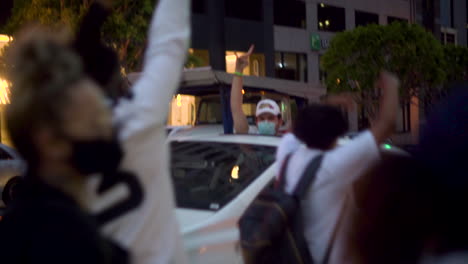 A-Man-holds-up-his-fist-through-the-sunroof-of-his-car-in-support-of-BLM-protesters-in-the-streets-of-Downtown