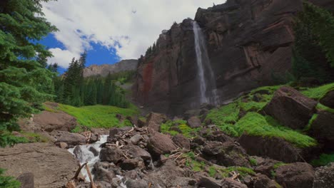 Summer-Telluride-Box-Canyon-Bridal-Veil-Falls-Waterfall-Colorado-landscape-static-shot-slowly-mist-spray-cliffside-Powerhouse-Hydroelectric-power-plant-Black-Bear-Pass-Board-sunny-blue-sky-clouds