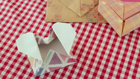 Folded-heart-shaped-origami-paper-envelopes-on-checkered-tablecloth