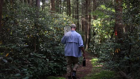 Slow-motion-footage-tracking-behind-a-fly-fisherman-walking-towards-the-stream