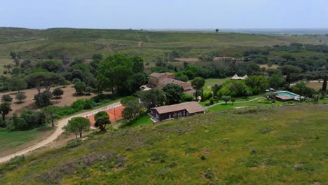 Aerial-shot-of-a-villa-with-a-private-swimming-pool-and-clay-tennis-court